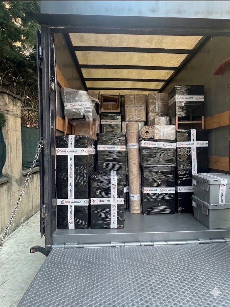 Evden eve nakliyat — Plus Nakliyat kamyonu, açık kasada paketlenmiş eşyalar